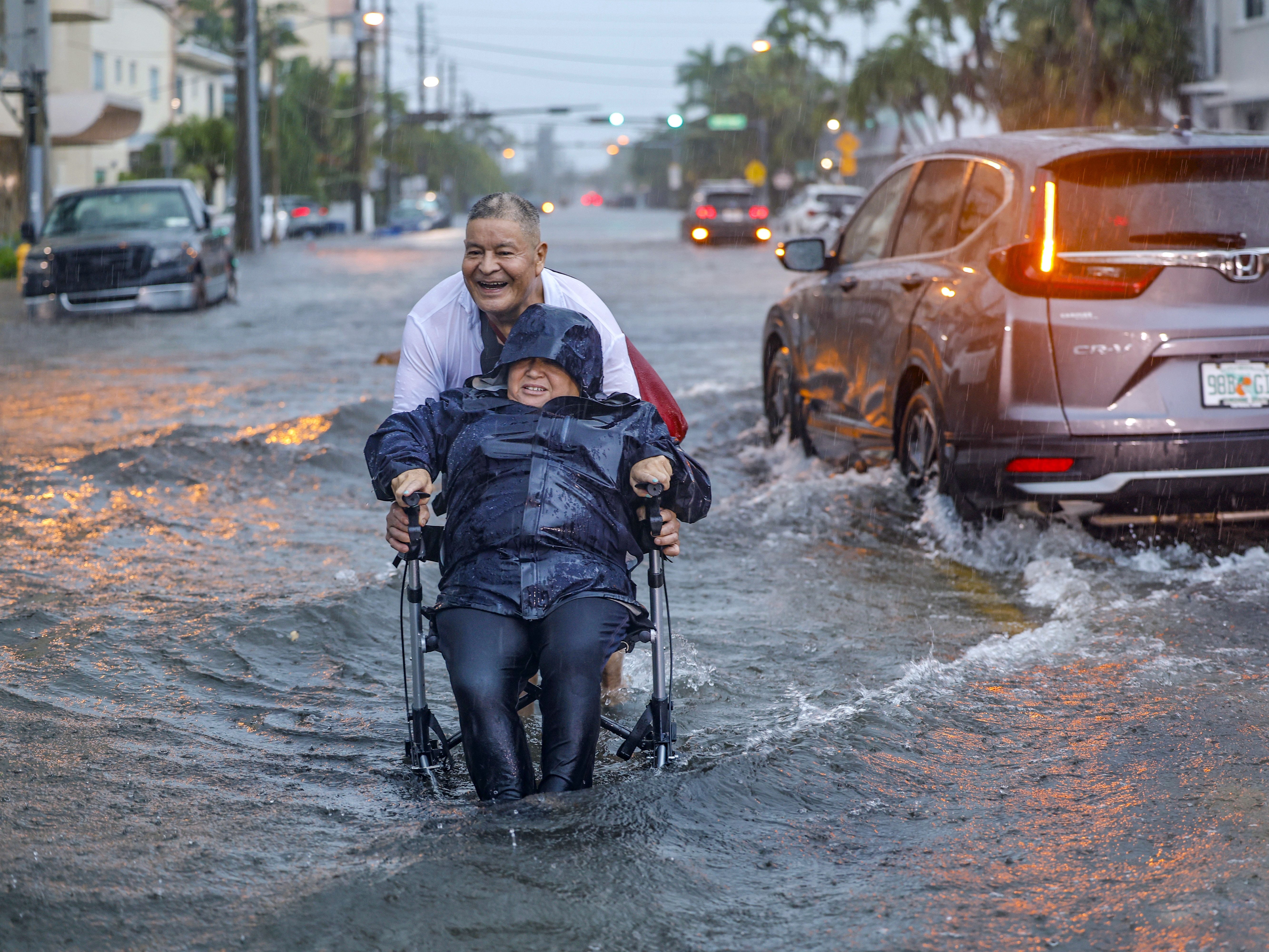 Victor Corone, 66, pushes his wife Maria Diaz, 64, in a wheelchair through more than a foot of floodwater in Miami Beach, Fla., on Wednesday, June 12, 2024. The annual rainy season has arrived with a wallop in much of Florida.